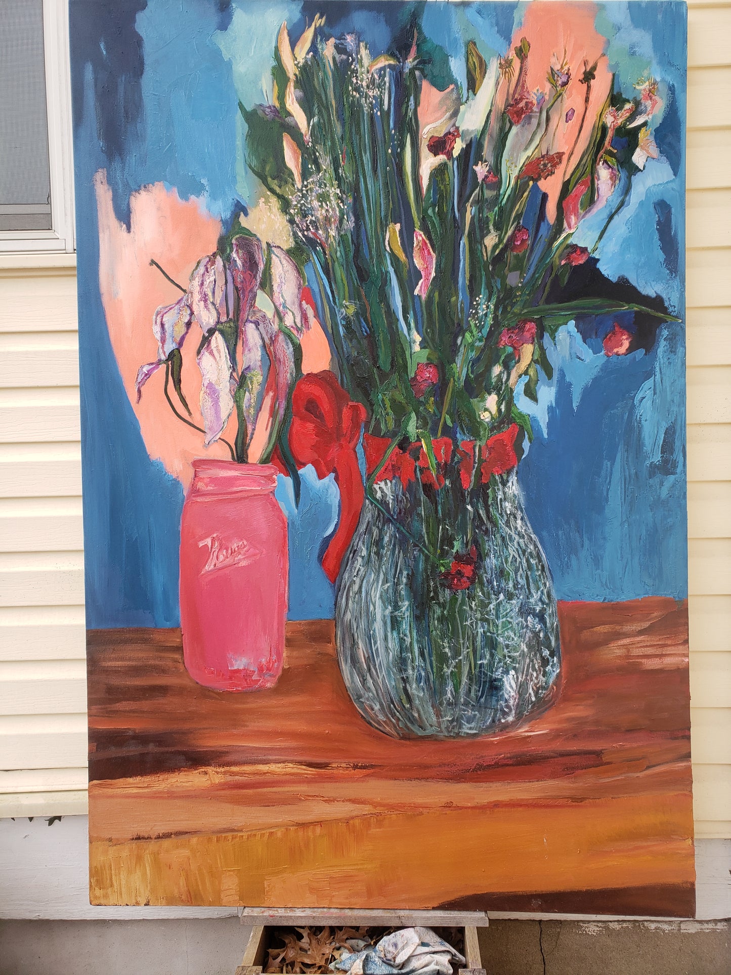 Colorful oil painting of flowers and a pink jar on a wooden surface